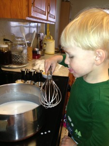 He's learning early - taste-testing while cooking is one of the best parts!