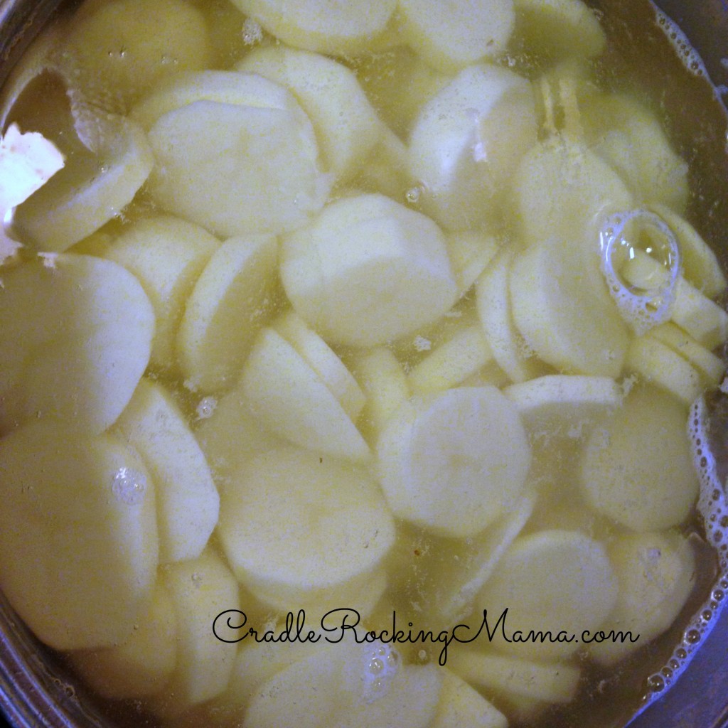 Potatos sliced with a mandolin and heating up on the stove.